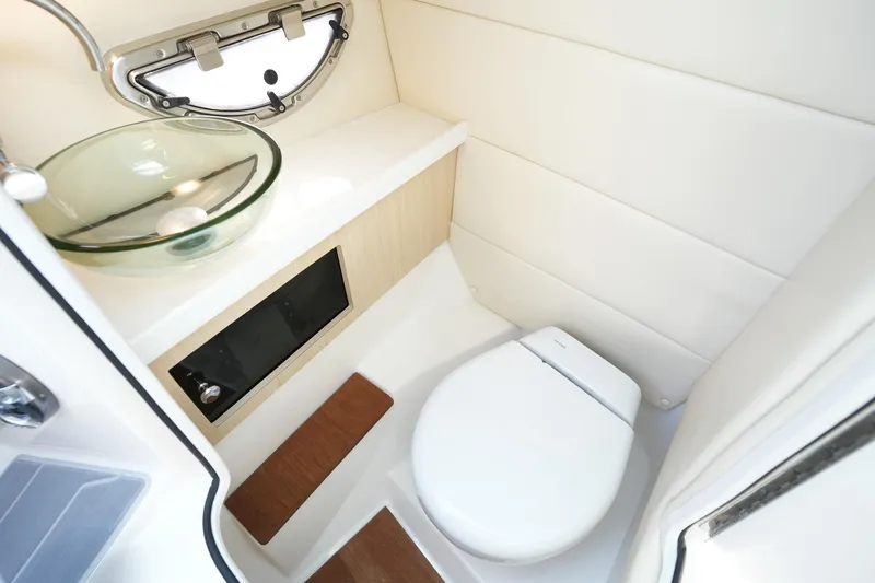  Yacht Photos Pics 2023 Regal 29 OBX boat bathroom with modern glass sink and compact toilet.