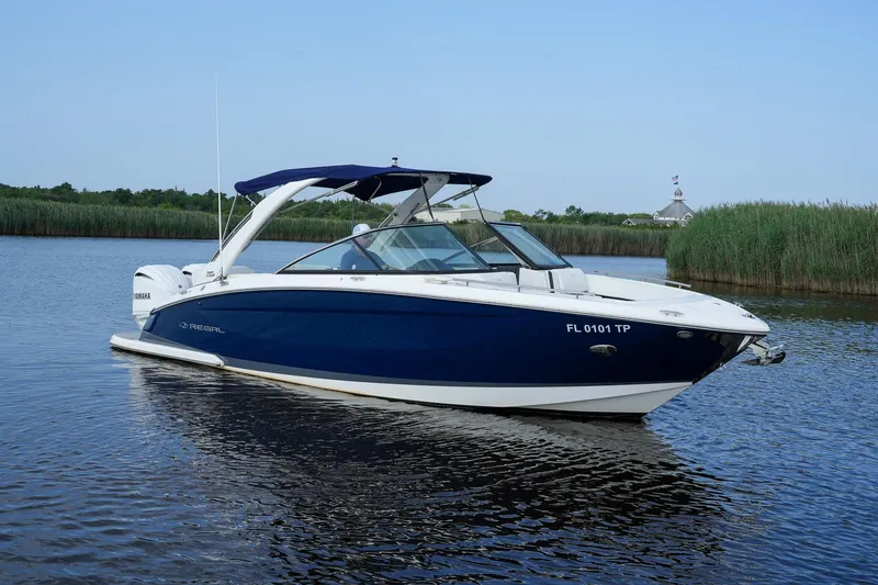  Yacht Photos Pics 2023 Regal 29 OBX boat on calm water, featuring sleek blue and white design.