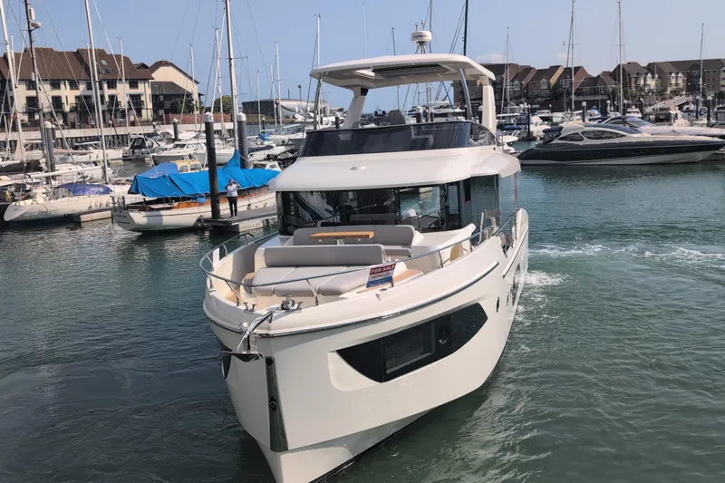 In Stock Yacht Photos Pics 2025 Absolute Navetta 53 yacht docked in a marina, surrounded by other boats.