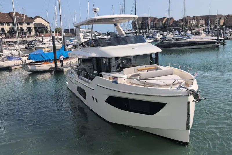 In Stock Yacht Photos Pics 2025 Absolute Navetta 53 yacht docked in a marina, surrounded by other boats.