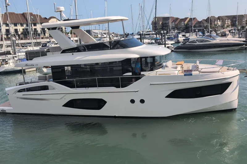 In Stock Yacht Photos Pics 2025 Absolute Navetta 53 yacht docked in marina, surrounded by other boats.