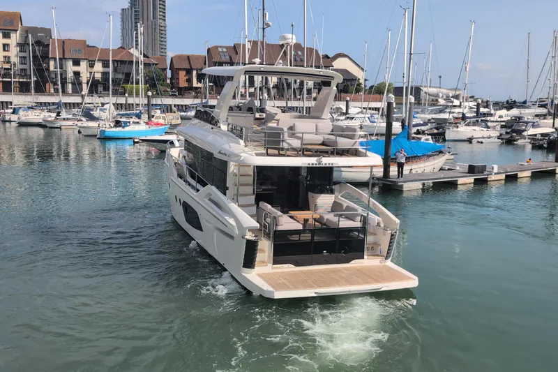 In Stock Yacht Photos Pics Luxury Absolute Navetta 53 yacht, 2025 model, docked in a marina with surrounding boats.