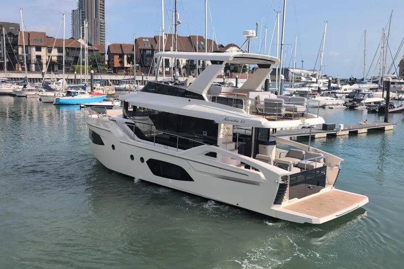In Stock Yacht Photos Pics 2025 Absolute Navetta 53 yacht docked in a marina, surrounded by other boats.