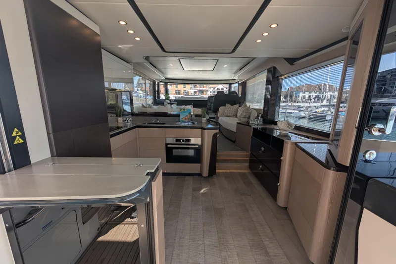 In Stock Yacht Photos Pics Luxurious interior of 2025 Absolute Navetta 53 yacht with modern kitchen and seating area.