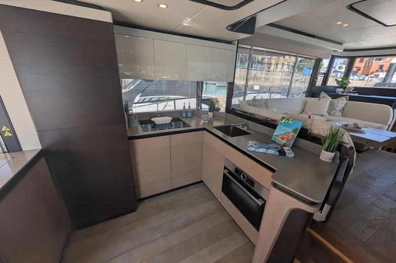 In Stock Yacht Photos Pics Luxurious interior of 2025 Absolute Navetta 53 yacht with modern kitchen and seating area.