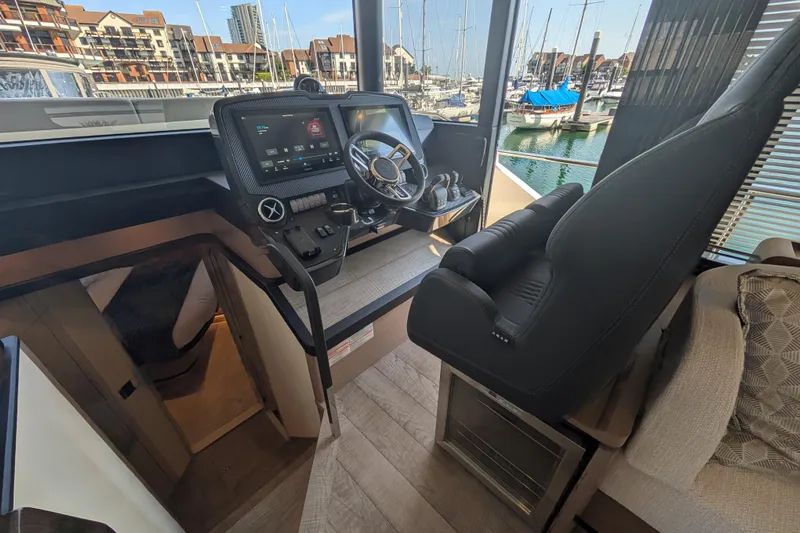 In Stock Yacht Photos Pics Interior helm of 2025 Absolute Navetta 53 yacht with modern controls and marina view.