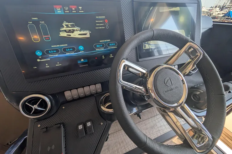 In Stock Yacht Photos Pics Cockpit of 2025 Absolute Navetta 53 yacht with advanced navigation display and steering wheel.