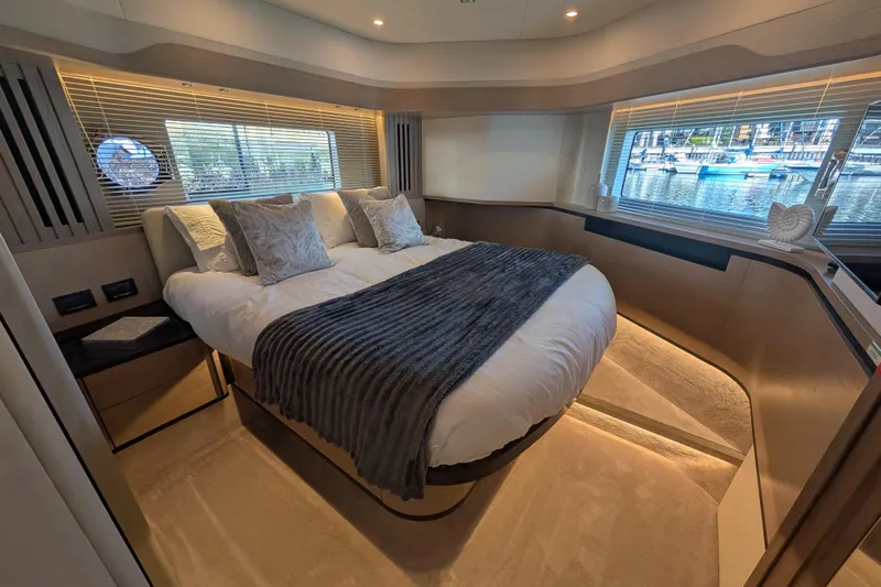 In Stock Yacht Photos Pics Luxurious bedroom interior of 2025 Absolute Navetta 53 yacht with elegant decor and marina view.