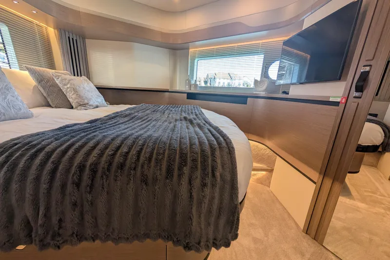In Stock Yacht Photos Pics Luxurious bedroom interior of 2025 Absolute Navetta 53 yacht with modern decor and cozy bedding.