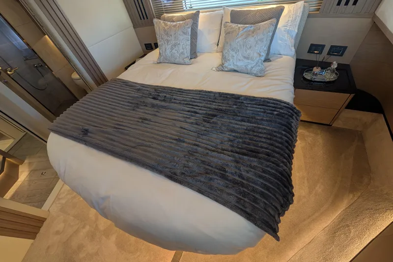 In Stock Yacht Photos Pics Luxurious bedroom interior of 2025 Absolute Navetta 53 yacht with plush bedding and elegant decor.