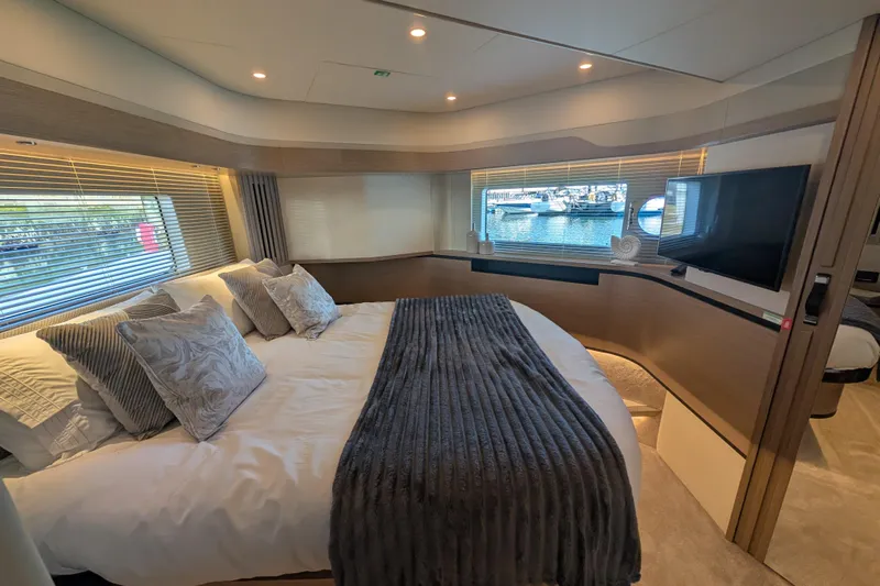 In Stock Yacht Photos Pics Luxurious bedroom interior of 2025 Absolute Navetta 53 yacht with elegant decor and marina view.
