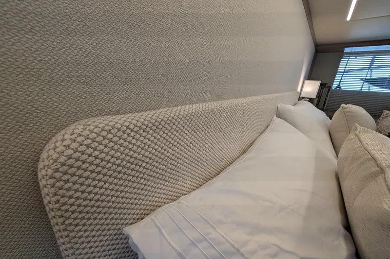 In Stock Yacht Photos Pics Luxurious interior of Absolute Navetta 53 yacht, featuring elegant bedding and textured wall design.