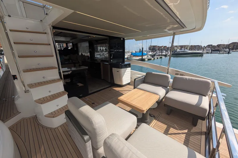 In Stock Yacht Photos Pics Luxurious 2025 Absolute Navetta 53 yacht deck with seating, table, and marina view.