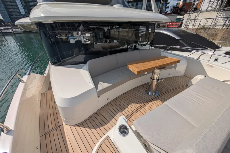 In Stock Yacht Photos Pics Luxurious 2025 Absolute Navetta 53 yacht with elegant deck seating and wooden table.