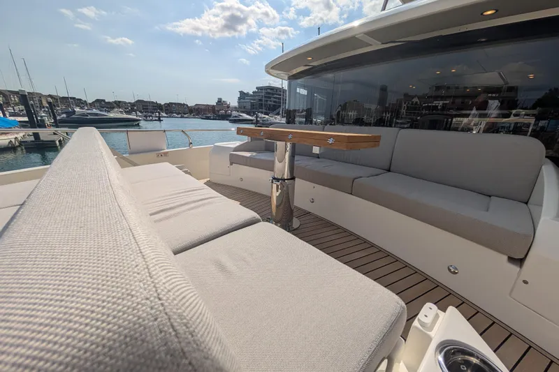 In Stock Yacht Photos Pics Luxurious seating area on 2025 Absolute Navetta 53 yacht, docked in a marina.