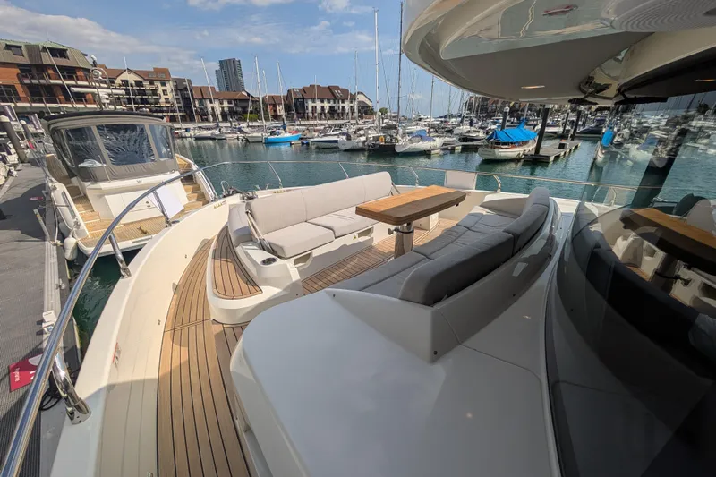 In Stock Yacht Photos Pics Luxurious 2025 Absolute Navetta 53 yacht docked at a marina, featuring elegant outdoor seating.