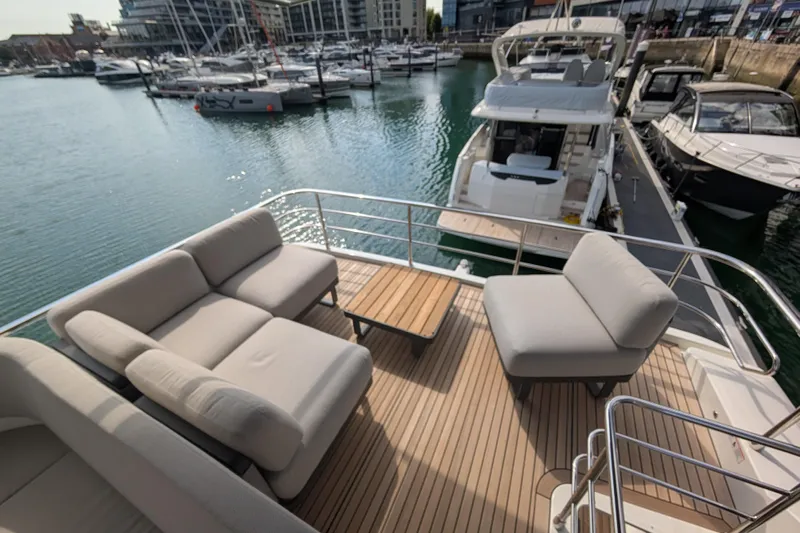 In Stock Yacht Photos Pics Luxurious deck of 2025 Absolute Navetta 53 yacht with comfortable seating in marina.