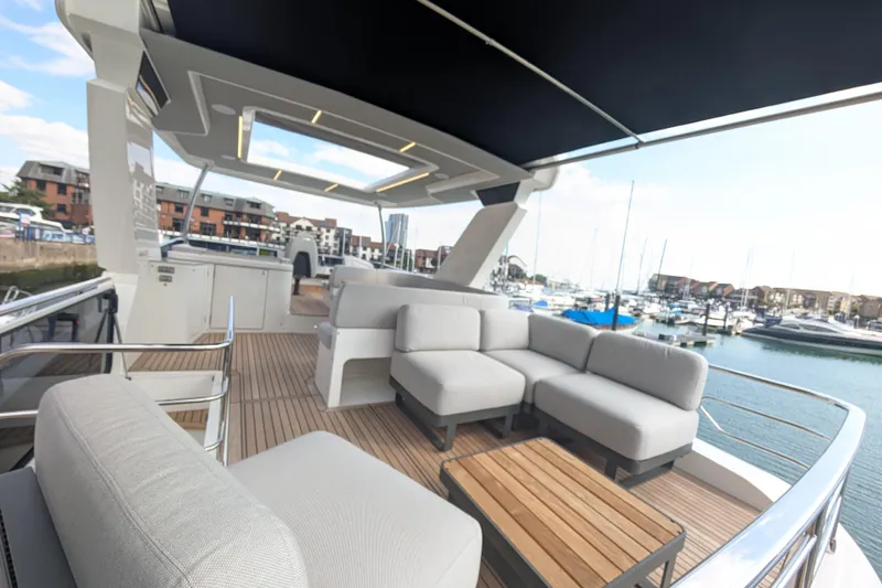 In Stock Yacht Photos Pics Luxurious deck of 2025 Absolute Navetta 53 yacht with modern seating and marina view.