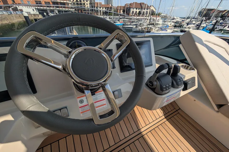 In Stock Yacht Photos Pics Steering wheel and controls of 2025 Absolute Navetta 53 yacht in marina setting.