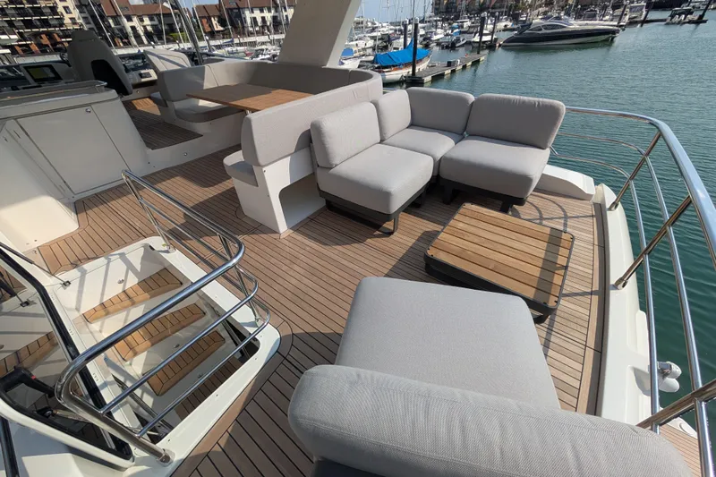 In Stock Yacht Photos Pics Luxurious deck of 2025 Absolute Navetta 53 yacht with modern seating and marina view.
