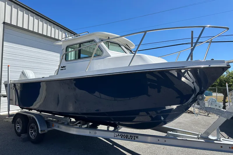  Yacht Photos Pics 2026 Parker 2220 boat on trailer, parked outside a garage.