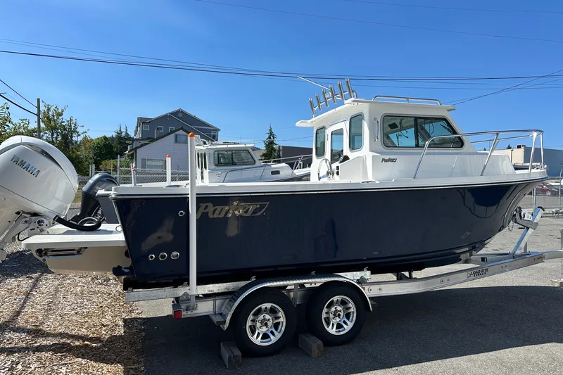  Yacht Photos Pics 2026 Parker 2220 boat on trailer with Yamaha engine, parked outdoors.
