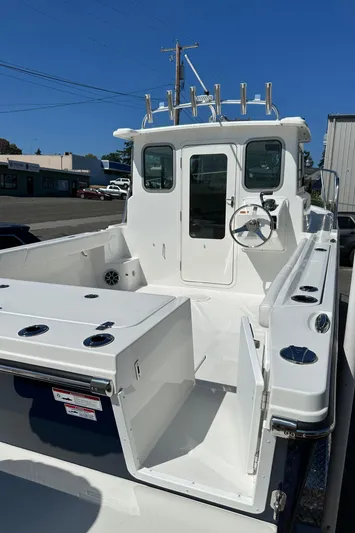  Yacht Photos Pics 2026 Parker 2220 boat, white deck, steering wheel, rod holders, clear sky background.