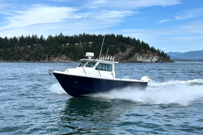  Yacht Photos Pics 2026 Parker 227 Explorer boat cruising on scenic water with forested island backdrop.