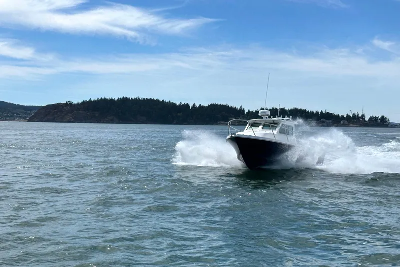  Yacht Photos Pics 2026 Parker 227 Explorer boat cruising on open water with scenic island backdrop.