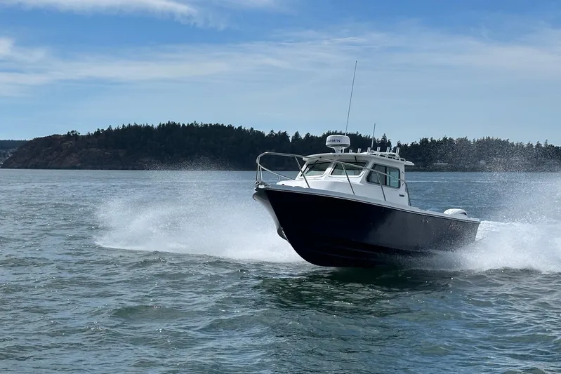  Yacht Photos Pics 2026 Parker 227 Explorer boat cruising on open water with scenic island backdrop.