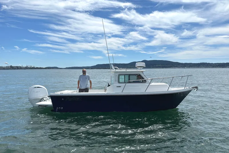  Yacht Photos Pics 2026 Parker 227 Explorer boat on water with person onboard, under a clear blue sky.