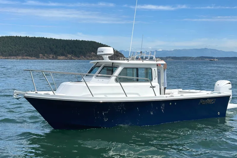  Yacht Photos Pics 2026 Parker 227 Explorer boat cruising on a scenic lake with forested hills.