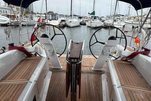 Cockpit view of 2017 Dehler 38 sailboat with dual steering wheels in marina.