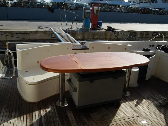  Yacht Photos Pics Outdoor seating area on 2009 Azimut 62 Evolution yacht with wooden table and cushioned benches.