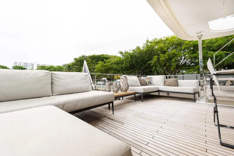 Amity Yacht Photos Pics Luxurious outdoor seating on 2018 Custom Line Navetta 33 yacht deck, surrounded by greenery.