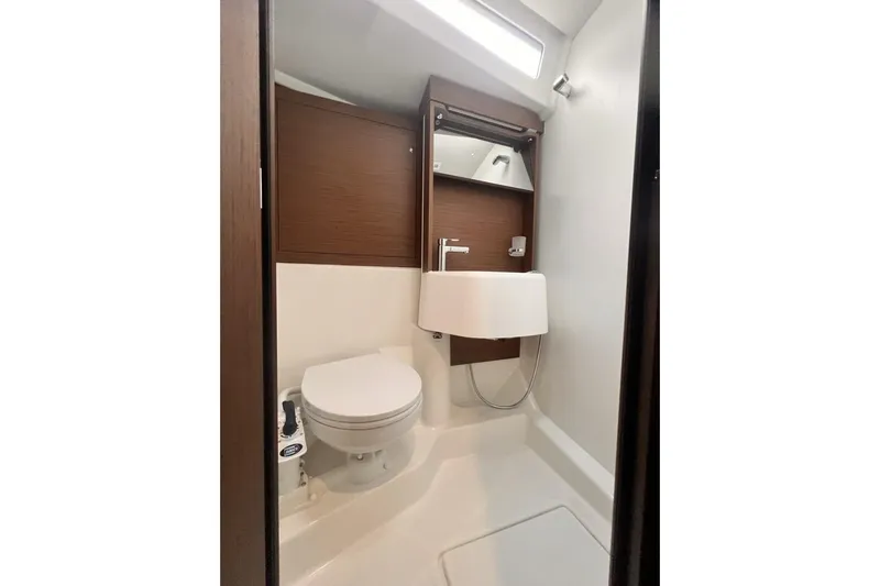 Yacht Photos Pics Modern bathroom in 2023 Beneteau Oceanis 51.1 yacht with sleek fixtures and wood accents.