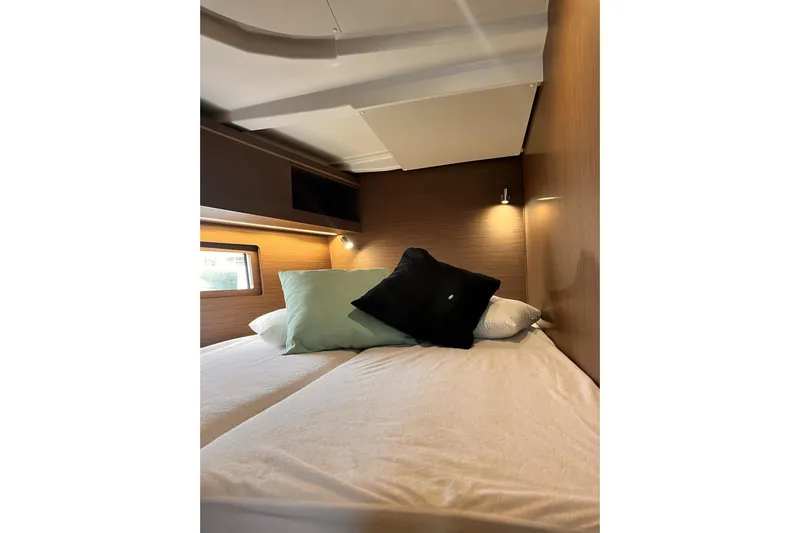  Yacht Photos Pics Cozy cabin interior of 2023 Beneteau Oceanis 51.1 yacht with pillows and soft lighting.