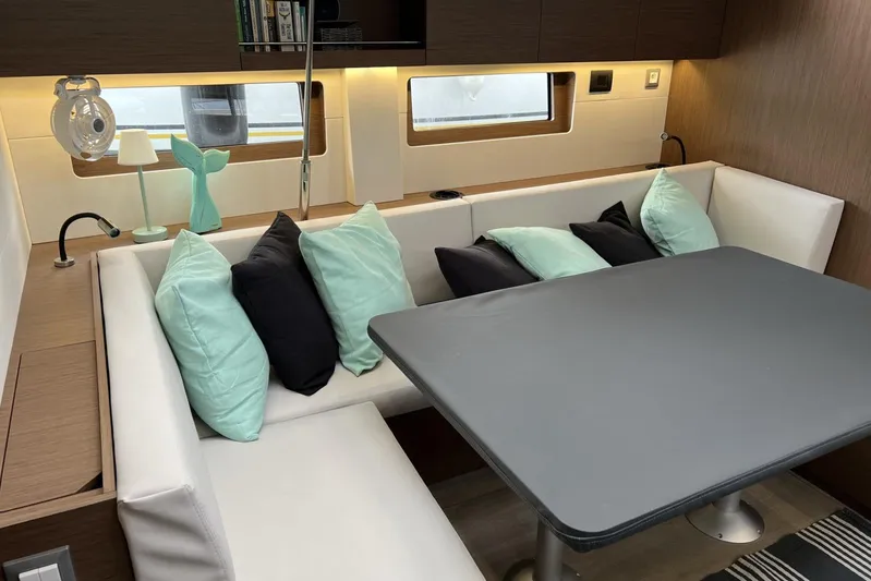  Yacht Photos Pics Interior of 2023 Beneteau Oceanis 51.1 yacht with modern dining area and cushions.
