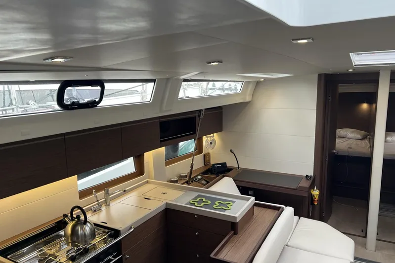  Yacht Photos Pics Luxurious interior of 2023 Beneteau Oceanis 51.1 yacht with modern kitchen and cozy cabin.