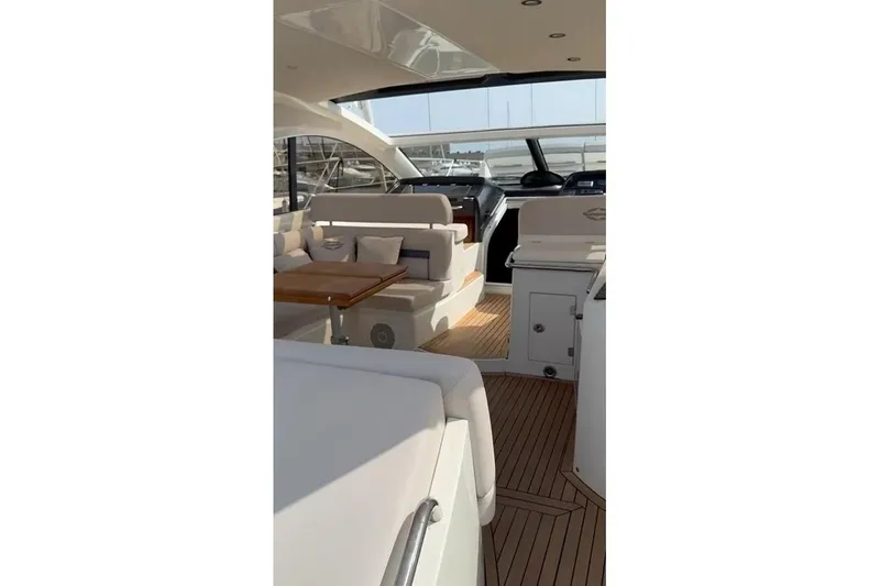  Yacht Photos Pics Interior view of 2010 Sunseeker Portofino 48 yacht, featuring elegant seating and wooden flooring.