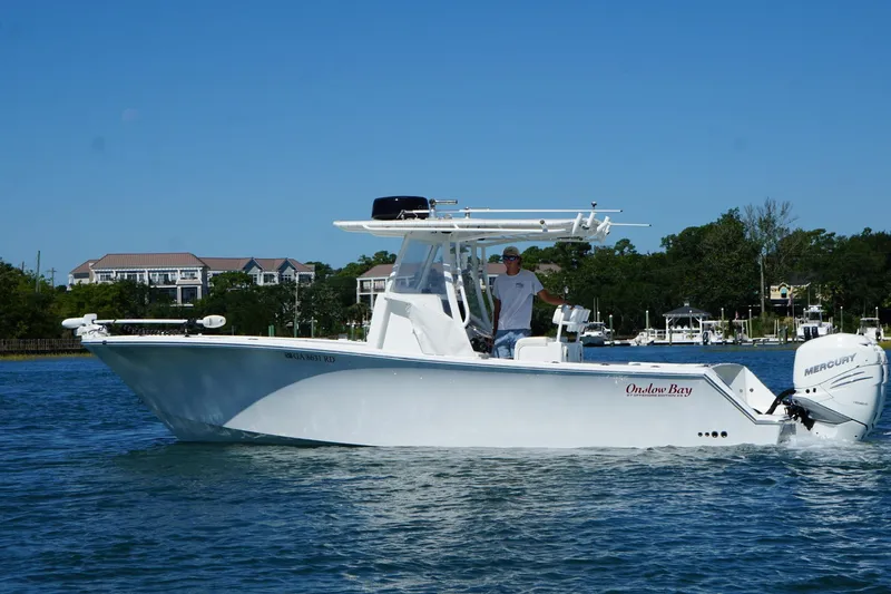  Yacht Photos Pics 2016 Onslow Bay 27 XS boat cruising on a sunny day with scenic waterfront backdrop.