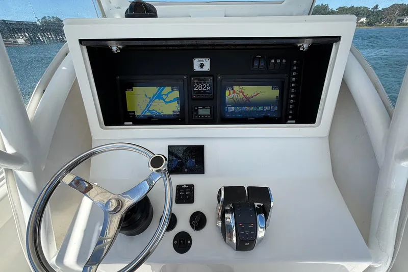  Yacht Photos Pics 2016 Onslow Bay 27 XS boat dashboard with navigation screens and steering wheel.