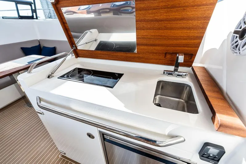  Yacht Photos Pics 2025 Makai M37 yacht kitchenette with sink, stove, and wooden accents.