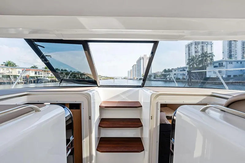  Yacht Photos Pics Interior view of 2025 Makai M37 yacht with wooden steps and waterfront cityscape.