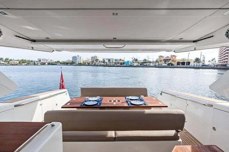  Yacht Photos Pics Luxurious Makai M37 yacht deck with dining setup, overlooking serene waterfront, 2025 model.