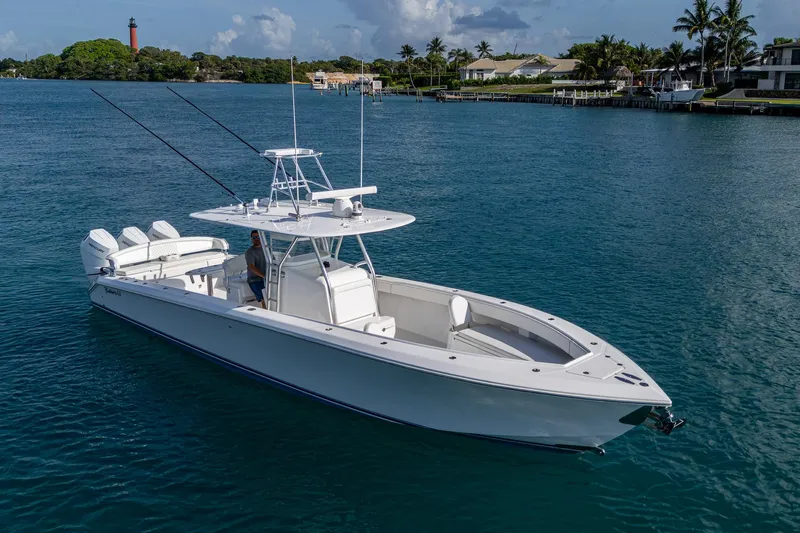 Irish Exit Yacht Photos Pics 2016 Bahama boat with Mercury V10 engines on calm water, lighthouse and houses in background.