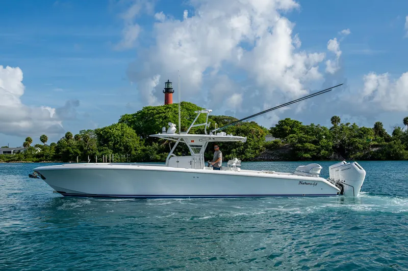 Irish Exit Yacht Photos Pics 2016 Bahama boat with Mercury V10 engines cruising near a lighthouse.