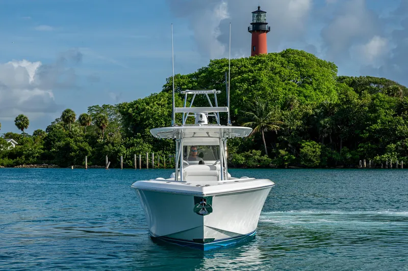 Irish Exit Yacht Photos Pics 2016 Bahama boat with Mercury V10 engines near a lighthouse and lush greenery.