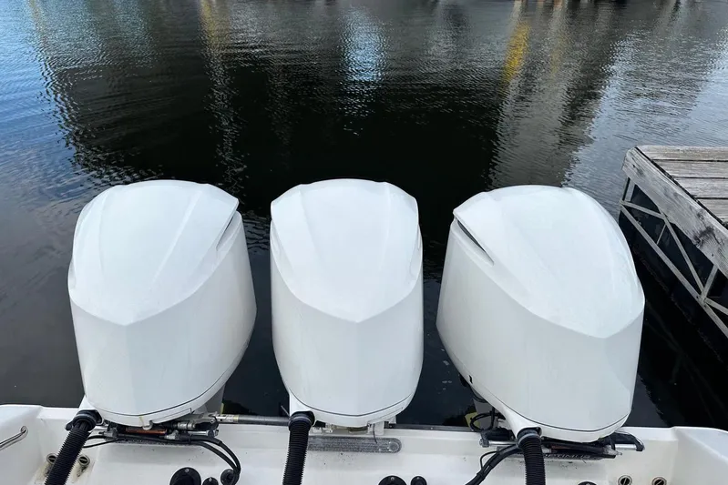  Yacht Photos Pics Triple outboard motors on a 2017 Edgewater 368CC boat by the water.