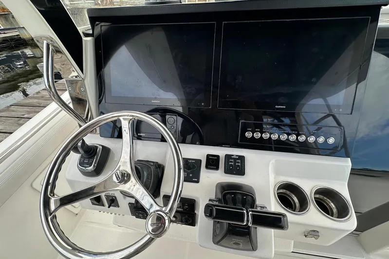  Yacht Photos Pics Control panel of 2017 Edgewater 368CC boat with dual Garmin screens and steering wheel.